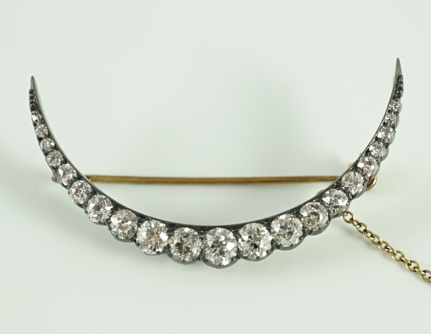 A Victorian, gold, silver and graduated twenty one stone diamond set crescent brooch